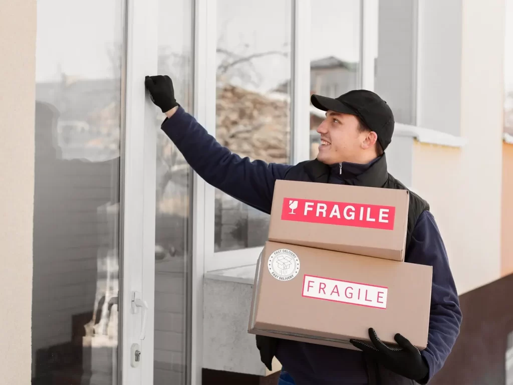 A Brightside delivery person wearing gloves and a cap knocks on a door while holding two boxes labeled "FRAGILE.